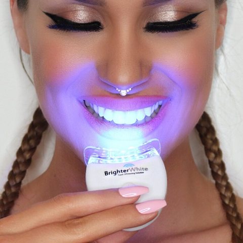 Woman using the BrighterWhite LED teeth whitening light